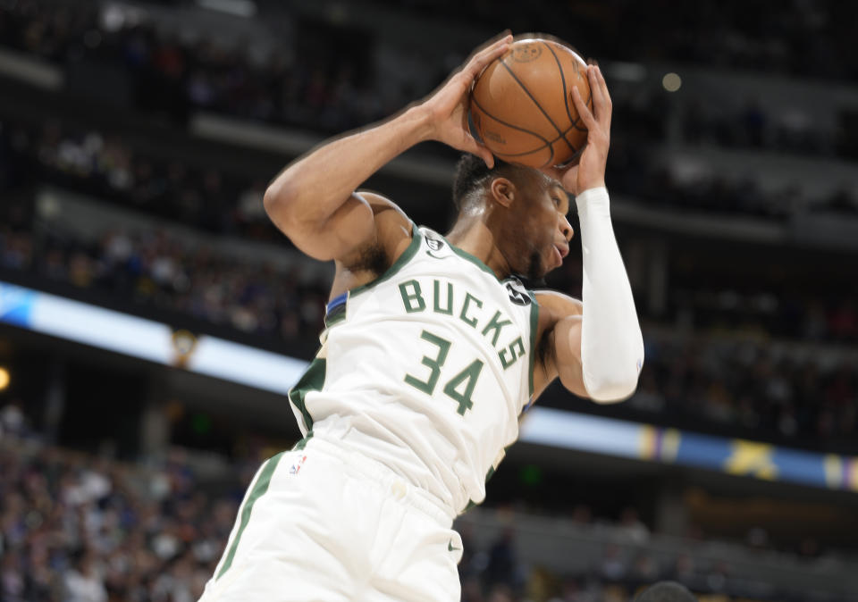 Milwaukee Bucks forward Giannis Antetokounmpo pulls un a rebound in the first half of an NBA basketball game against the Denver Nuggets Saturday, March 25, 2023, in Denver. (AP Photo/David Zalubowski)