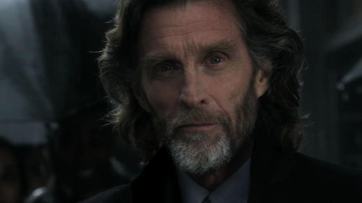actor john glover in the role of lionel luthor in smallville with the actor has long shoulder length hair and is staring at the camera