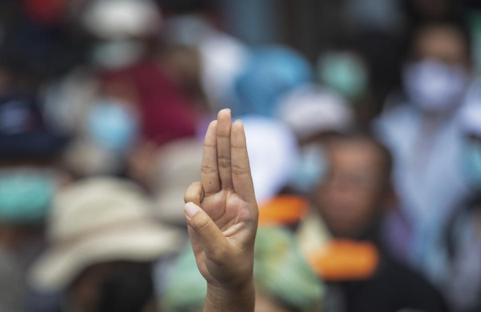 An anti-government protester raises a three-fingered salute, a symbol of resistance, as they march from Democracy Monument to government house in Bangkok, Thailand, Wednesday, Oct. 14, 2020. Anti-government protesters began gathering Wednesday for a planned rally at Bangkok's Democracy Monument being held on the anniversary of a 1973 popular uprising that led to the ousting of a military dictatorship, amid a heavy police presence and fear of clashes with political opponents. (AP Photo/Sakchai Lalit)