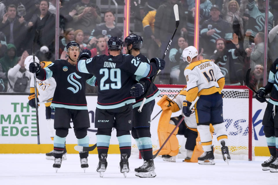 Seattle Kraken center Jaden Schwartz, left, comes over to celebrate with defenseman Vince Dunn (29) and center Alex Wennberg after Dunn scored, while Nashville Predators center Colton Sissons (10) skates past during the third period of an NHL hockey game Thursday, Nov. 2, 2023, in Seattle. (AP Photo/Lindsey Wasson)