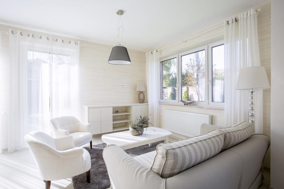 A living room with white chairs and a white and gray couch with no TV in room