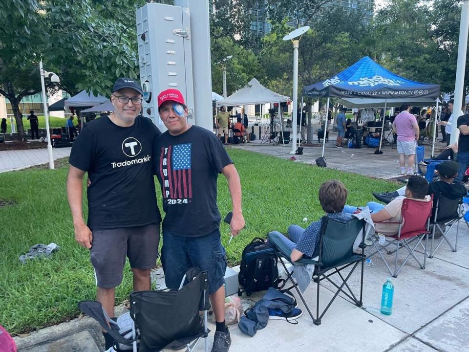 As the sun rose Tuesday, Raj Abhyanker, left, and Lazaro Encenarro hold their spots in line for the Trump court hearing outside the federal courthouse on Tuesday, June 19, 2023.