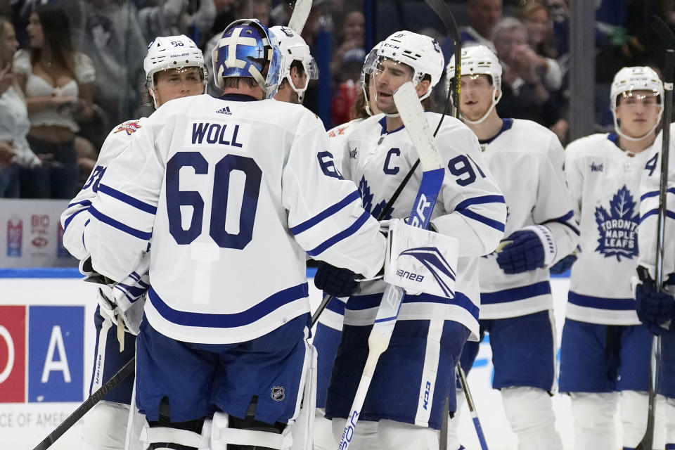 Toronto Maple Leafs goaltender Joseph Woll (60) celebrates with center John Tavares (91) after the team defeated the takes a break during a stoppage in play against the during overtime of an NHL hockey game Saturday, Oct. 21, 2023, in Tampa, Fla. (AP Photo/Chris O'Meara)