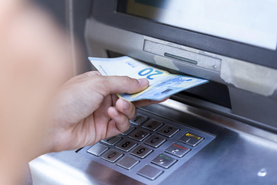 Close up of businesswoman withdraw money on a cash machine