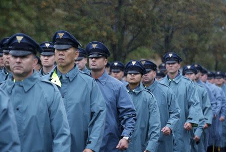 New York State Police officers march in the rain near the Greater Allen A.M.E. Cathedral of New York ahead of the funeral service for slain New York City Police (NYPD) officer Randolph Holder in the Queens borough of New York City, October 28, 2015. REUTERS/Brendan McDermid