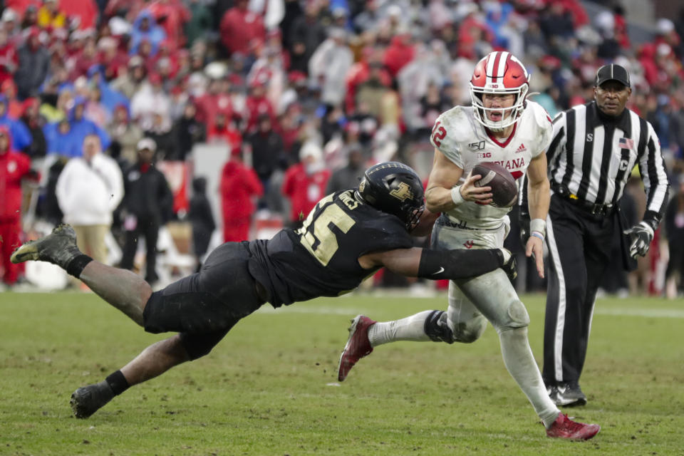 Indiana quarterback Peyton Ramsey (12) tries to scramble away from Purdue defensive end Derrick Barnes (55) during the second half of an NCAA college football game in West Lafayette, Ind., Saturday, Nov. 30, 2019. Indiana defeated Purdue 44-41 in double overtime. (AP Photo/Michael Conroy)