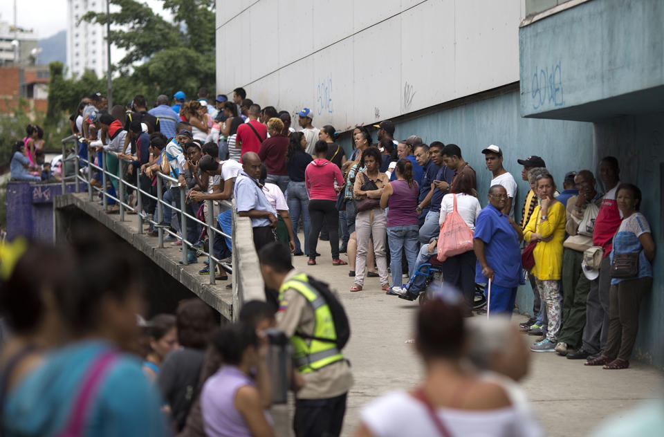 <p>People wait outside a supermarket to buy government subsided food in Caracas, Venezuela, Nov. 18, 2016. As domestic production dries up in Venezuela, the state has given itself the role of importing nearly all the country’s food. (Ariana Cubillos/AP) </p>