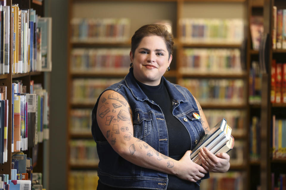 Chaz Carey poses for a photo at a library in Worthington, Ohio, Tuesday, June 11, 2024. Carey, a youth services librarian who is queer, knows firsthand how powerful books can be. Alison Bechdel's 2006 graphic memoir “Fun Home," in which the author comes to grips with her sexual orientation, changed Carey's life as a teenager. (AP Photo/Joe Maiorana)