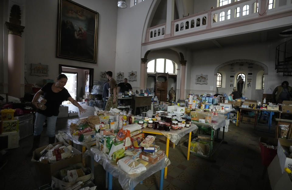 FILE - Victims of flooding shop for items distributed by volunteers at the town church in Trooz, Belgium, July 27, 2021. Across Europe, the continent that nurtured Christianity for most of two millennia, many churches, convents, beguinages and chapels stand empty as faith and church attendance have dwindled over the past half century. Many are now been repurposed to preserve their historical and architectural relevance, while others have opened up to non-religious activities to expand their use. (AP Photo/Virginia Mayo, File)