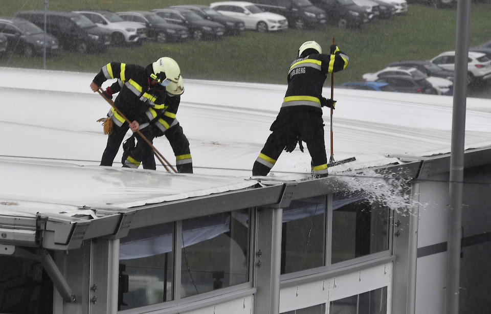 Bomberos trabajan para sacar el exceso de agua causado por fuertes aguaceros en un techo el sábado junto a la pista de Red Bull Ring, antes de la tercera sesión de prácticas para el Gran Premio de F1 de Estiria, el sábado, 11 de juliio del 2020. (Joe Klamar/Pool vía AP)