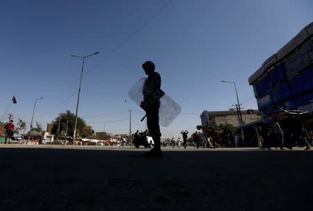 An Afghan policeman keeps watch during a demonstration by Afghanistan's Hazara minority in Kabul, Afghanistan July 23, 2016. REUTERS/Mohammad Ismail