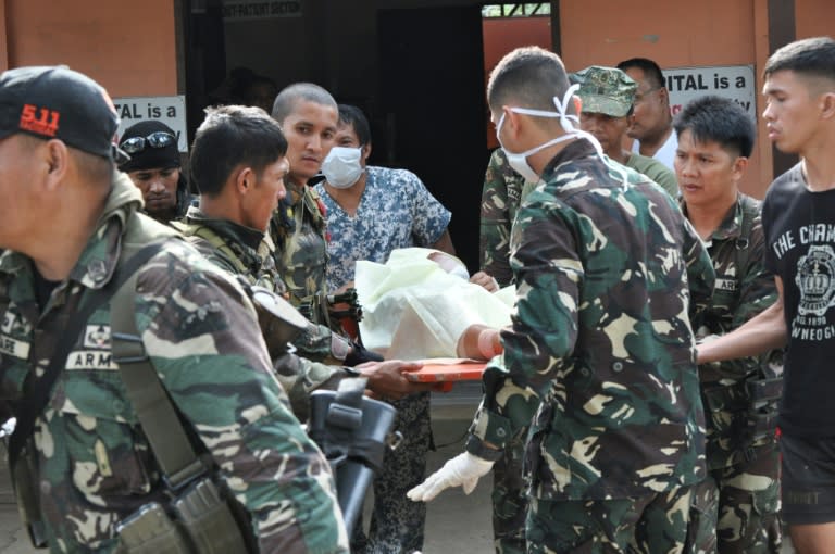 Philippine soldiers evacuate a comrade wounded during clashes with Abu Sayyaf fighters from a military camp in Jolo town, Sulu province, on the southern island of Mindanao on February 25, 2015