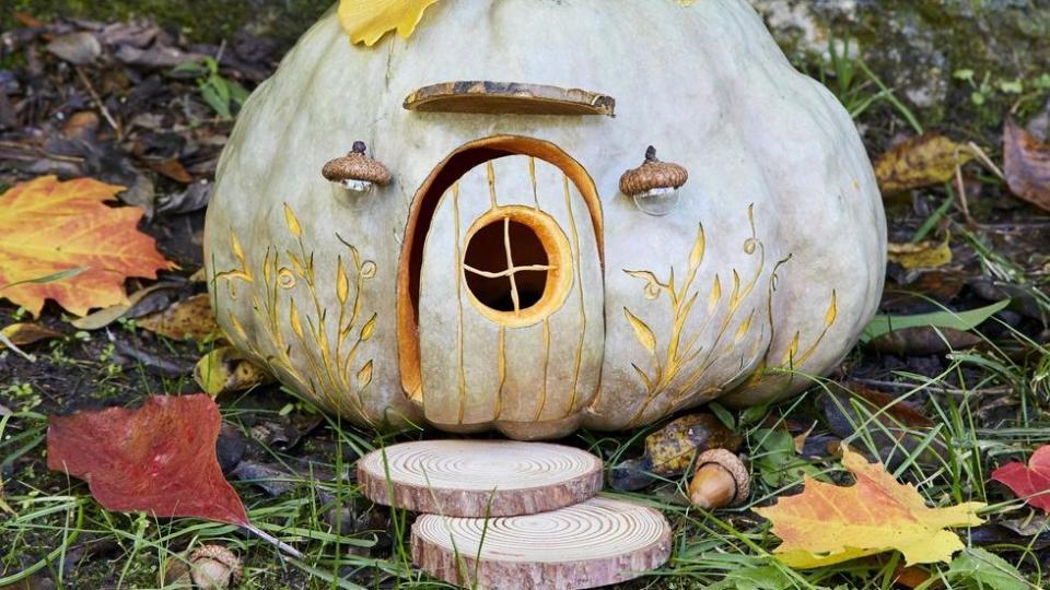two story pumpkin fairy house decorated with gingko leaves that adults and kids can make together for a halloween activity