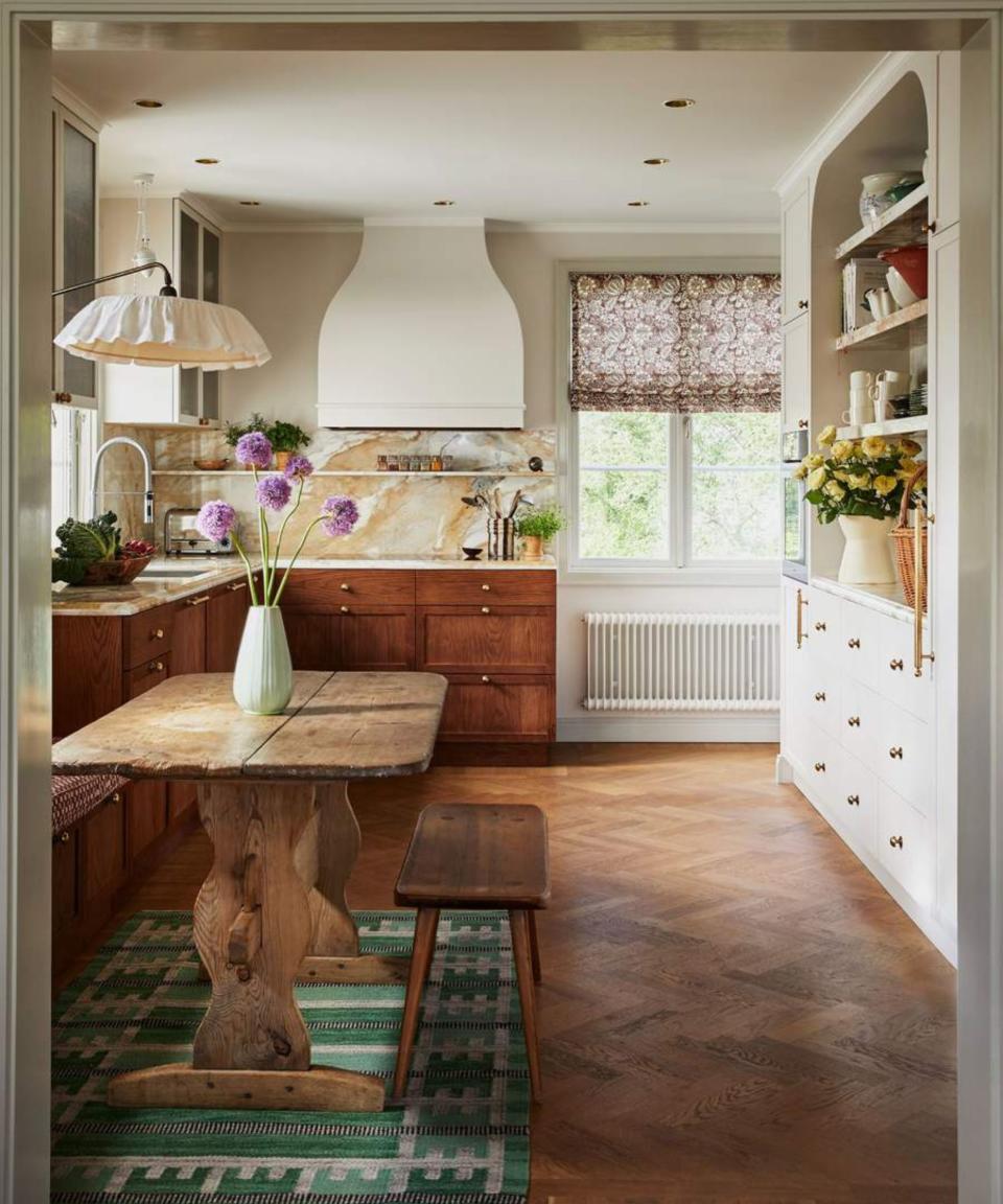 Kitchen looking to window with shelves on right and dining table in foreground