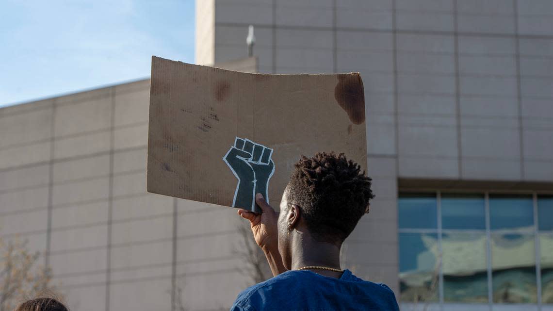 A community member holds up a sign depicting a fist while attending a rally for Ralph Yarl in front of the Charles E. Whittaker U.S. Courthouse on Tuesday, April 18, 2023, in Kansas City.