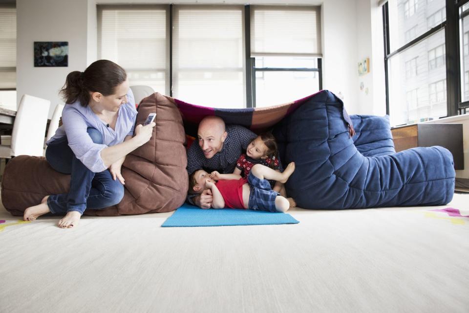 family playing in pillow fort