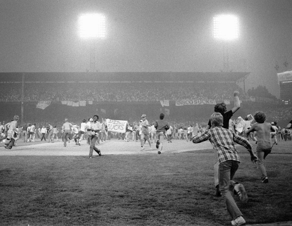 FILE - In this July 12, 1979, file photo, fans storm the field at Chicago's White Sox Park on Disco Demolition night after the first game of a doubleheader between the White Sox and Detroit Tigers. The promotion by a local radio station turned into a melee after hundreds of disco records were blown up on the field. The second game of the doubleheader was called by umpires who declared the field unfit for play. (AP Photo/Fred Jewell, File)