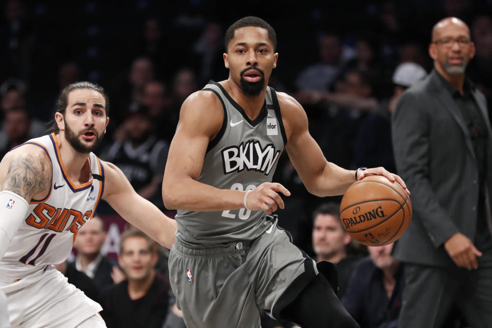 Brooklyn Nets guard Spencer Dinwiddie (26) drives around Phoenix Suns guard Ricky Rubio (11) as Phoenix Suns head coach Monty Williams looks on during the first quarter of an NBA basketball game, Monday, Feb. 3, 2020, in New York. (AP Photo/Kathy Willens)