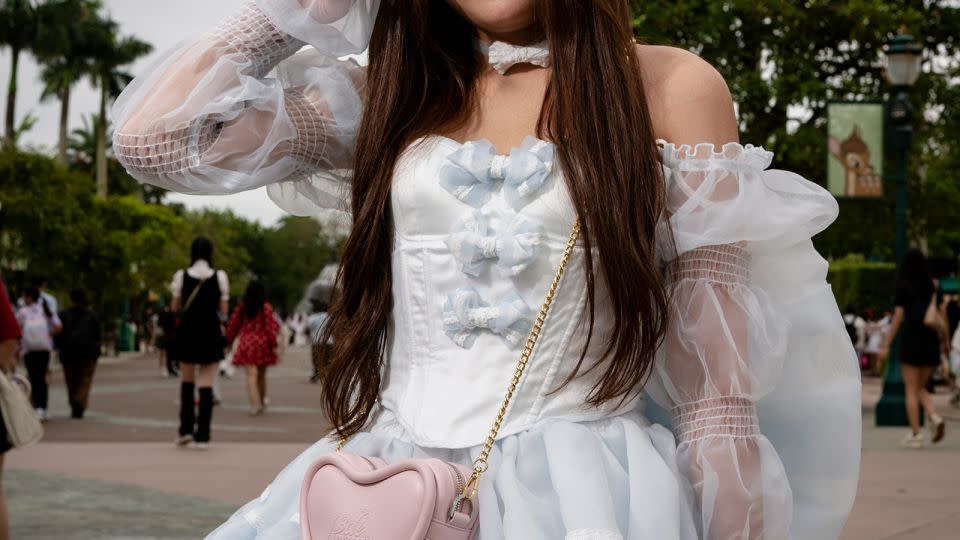 Li Mengru, 27, poses for a picture during an interview with CNN, at the entrance of Hong Kong Disneyland on June 7, 2024. - Noemi Cassanelli/CNN