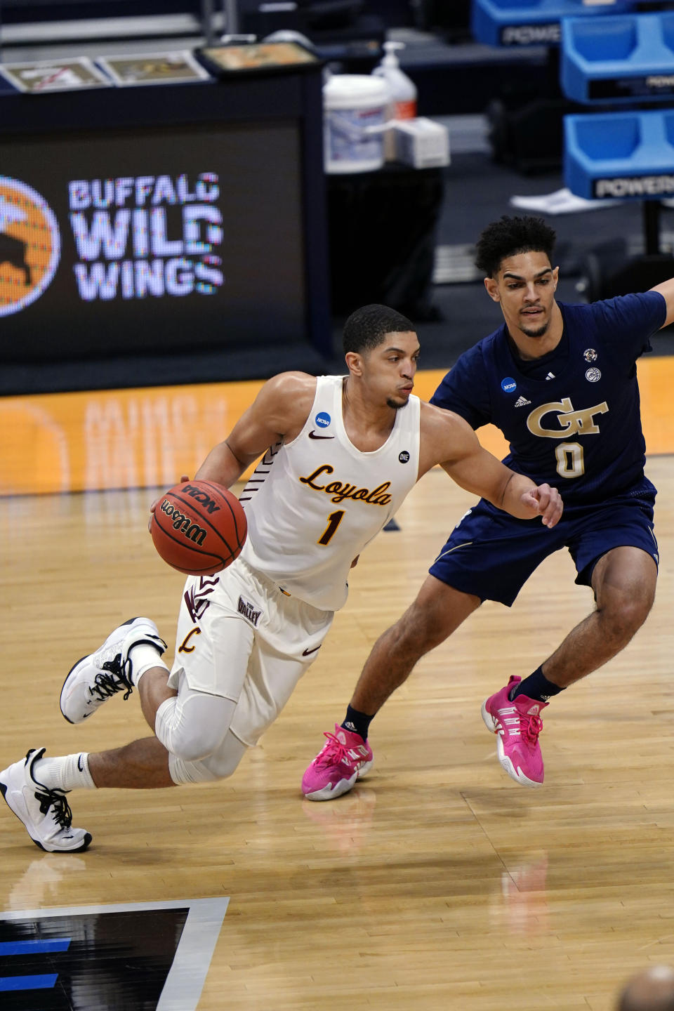 Loyola Chicago guard Lucas Williamson (1) drives around Georgia Tech guard Michael Devoe (0) in the first half of a college basketball game in the first round of the NCAA tournament at Hinkle Fieldhouse, Indianapolis, Friday, March 19, 2021. (AP Photo/AJ Mast)