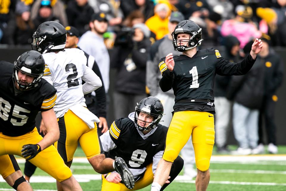 Iowa placekicker Aaron Blom (1) kicks a field goal with a hold from Tory Taylor during the Hawkeyes' final spring football practice in April.