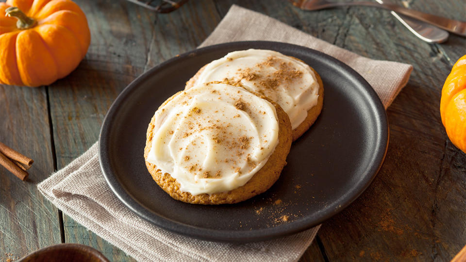 Pumpkin cookies with cheesecake icing served on a plate