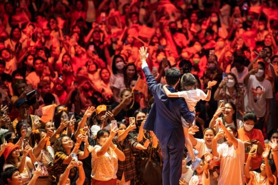 Pita waves to supporters while holding his daughter Pipim at a Move Forward rally in Bangkok in May. <span class="copyright">Sirachai Arunrugstichai—Getty Images</span>