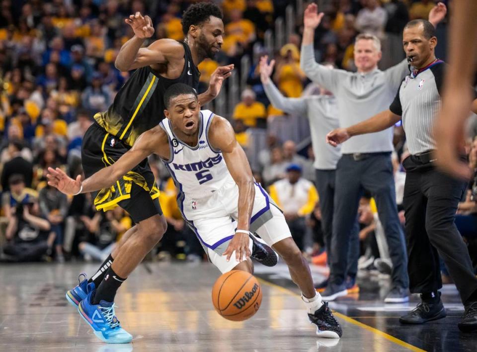 Sacramento Kings guard De’Aaron Fox (5) drives against Golden State Warriors forward Andrew Wiggins (22) during Game 3 of the first-round NBA playoff series at Chase Center in San Francisco on Thursday, April 20, 2023.