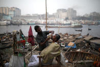 <p>Ein Mann lässt sich am Ufer des Flusses Buriganga in Bangladesch seinen Bart schneiden. (Bild: Reuters/Mohammad Ponir Hossain) </p>