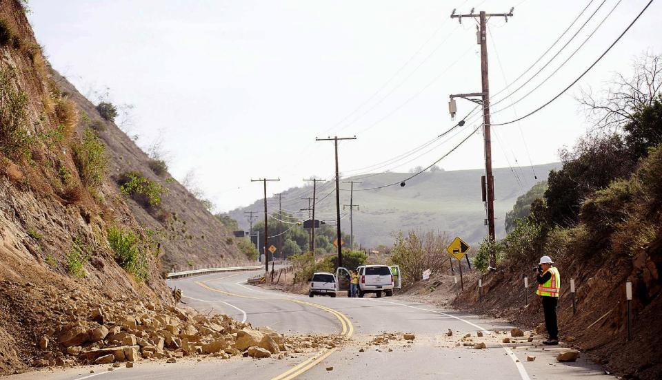 David Richardson, empleado del Departamento de Transporte de California, toma fotografías del desprendimiento de rocas que causó el cierre de Carbon Canyon Road cerca del Parque Regional Carbon Canyon en Brea, California, el sábado 29 de marzo de 2014, luego que un sismo de magnitud de 5,1 sacudió el Condado de Orange el viernes por la noche. No ha habido reportes de personas heridas. (Foto AP/The Orange County Register, Ken Steinhardt)