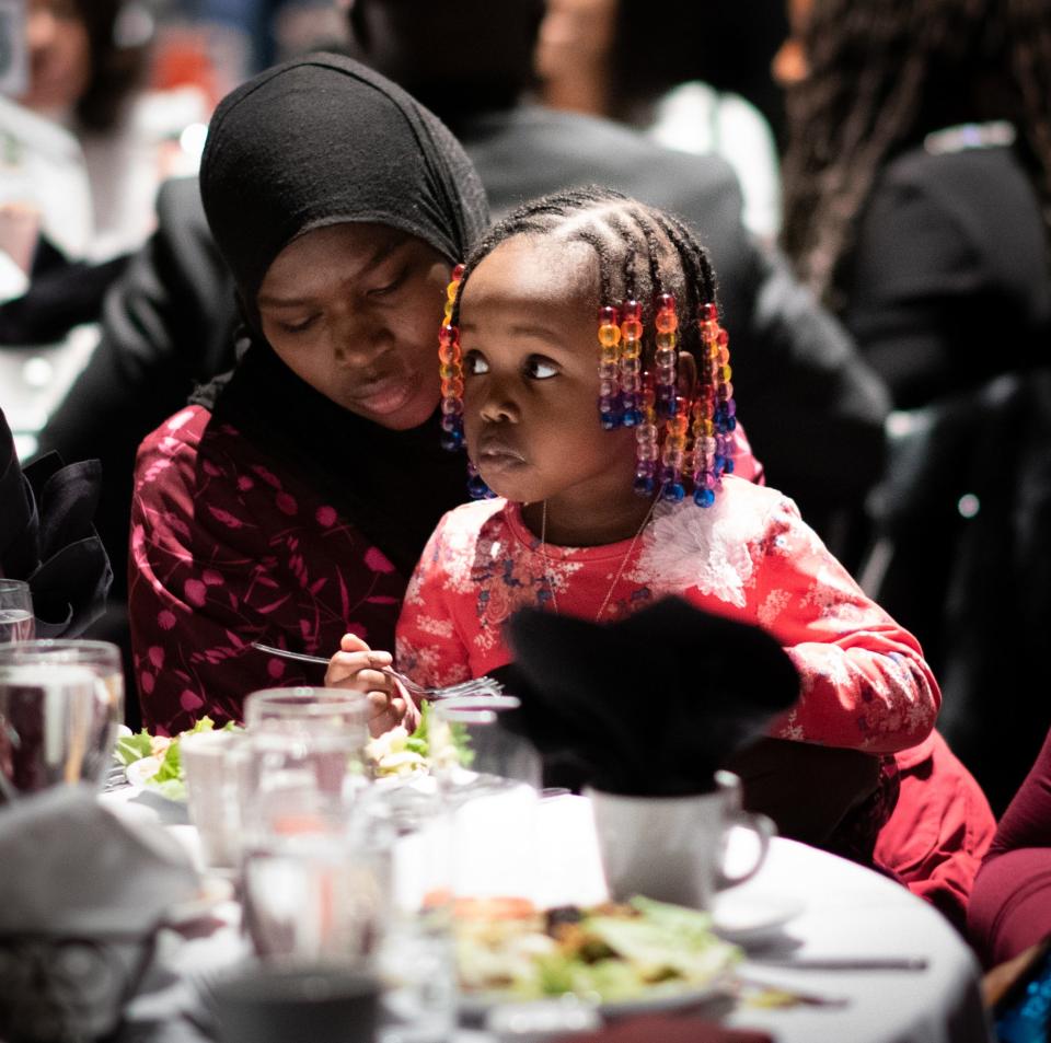 Chiffa Hassan, 17, a student at Everett High School, holds sister Tysir Adam, 3, Monday, Jan. 20, 2020, during the 35th Annual Martin Luther King Jr. Day of Celebration Luncheon at the Lansing Center. Hassan and her family are refugees from Sudan.  Chiffa was a 2020 scholarship award winner.  Her older sister won a scholarship last year.