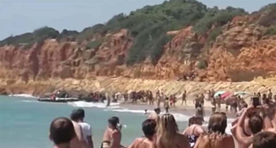 Footage shows the boat landing on the shore at Barossa beach in Cadiz, Spain as the Moroccan migrants jump out and climb up a rock face. Source: El Pais