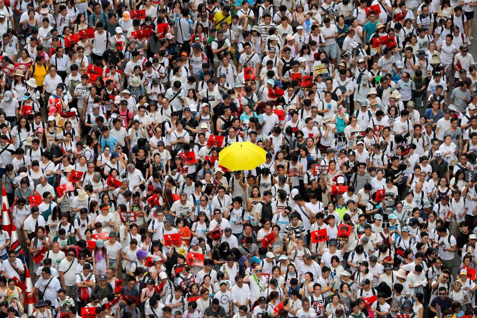 In this Sunday, June 9, 2019, file photo, a protester holds up a yellow umbrella as he and others march in a rally against the proposed amendments to extradition law in Hong Kong.