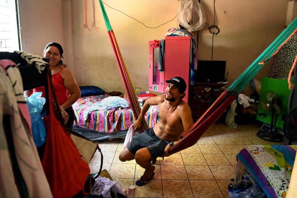 Surfer Bryan Perez sits in the room where he grew up with his mother Maria Perez