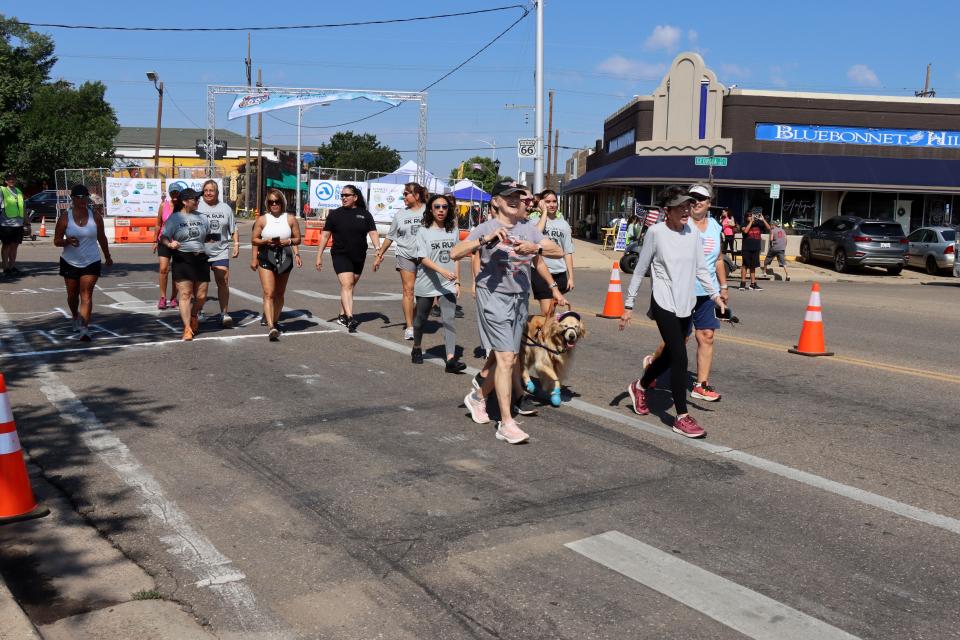 Participants walk on 6th Street early Saturday during the Fitness @ KT Black 1K Walk, which was part of the Texas Route 66 Festival this year.