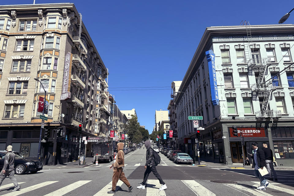 Pedestrians cross Leavenworth Street in the Tenderloin neighborhood of San Francisco, Thursday, March 14, 2024. Two hotels and unnamed residents of one of San Francisco's most problematic neighborhoods for drug use and tent encampments sued the city Thursday, demanding that city officials stop using the district as a containment zone. (AP Photo/Jeff Chiu)