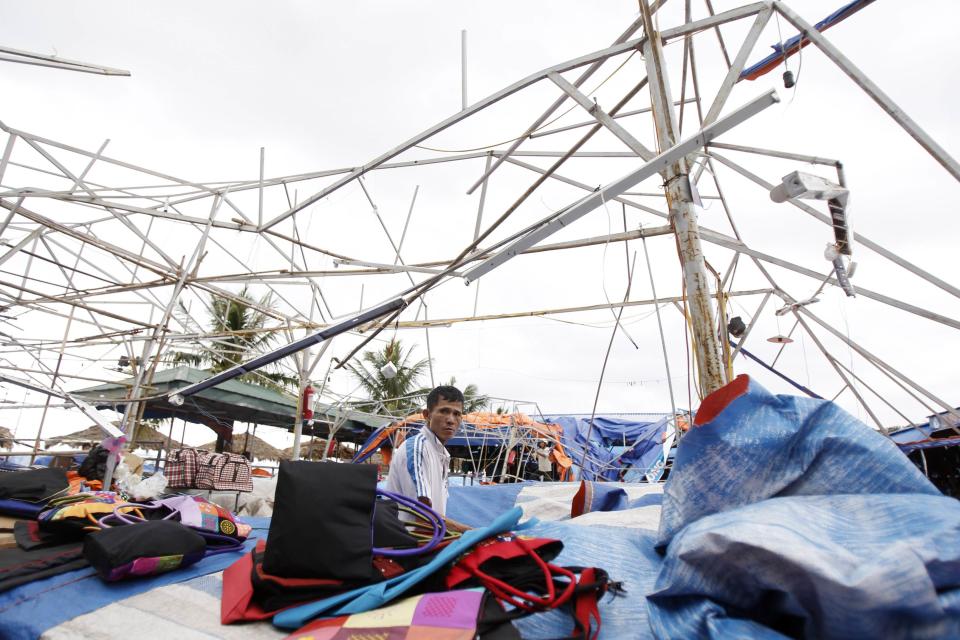 A man sits at his damaged shop in the aftermath of typhoon Haiyan in Vietnam's northern Quang Ninh province, 180 km (112 miles) from Hanoi November 11, 2013. Thirteen people were killed and dozens hurt during heavy winds and storms in Vietnam as Haiyan approached the coast, state media reported, even though it had weakened substantially after hitting the Philippines. Vietnam authorities have moved 883,000 people in 11 central provinces to safe zones, according to the government's website. A further 150,000 people were moved to safe areas in northern provinces, authorities said. (REUTERS/Kham)