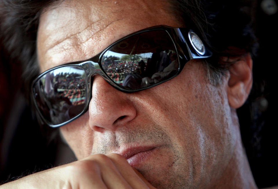 FILE - In this April 24, 2011 file photo, Pakistani cricket legend and now turned politician Imran Khan listens to the speech of a politician during a rally against the U.S. drone strikes in Pakistani tribal areas in Peshawar, Pakistan. He won the cricket World Cup for Pakistan in 1992 when the country's prime minister was Nawaz Sharif. Twenty six years later the charismatic Imran Khan is all set to become the first cricketer in the world to be elected as a country's prime minister in Wednesday, July 25, 2018 elections. (AP Photo/Mohammad Sajjad, File)