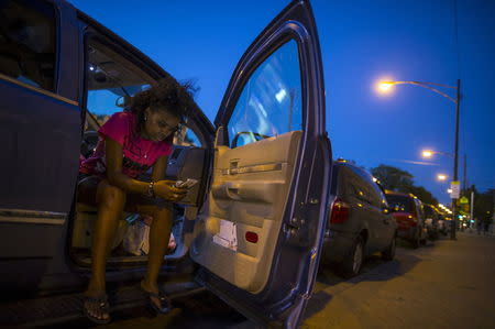 Mothers Against Senseless Killings (MASK) founder Tamar Manasseh checks her messages in her car in the Englewood neighborhood in Chicago, Illinois, United States, August 3, 2015. REUTERS/Jim Young