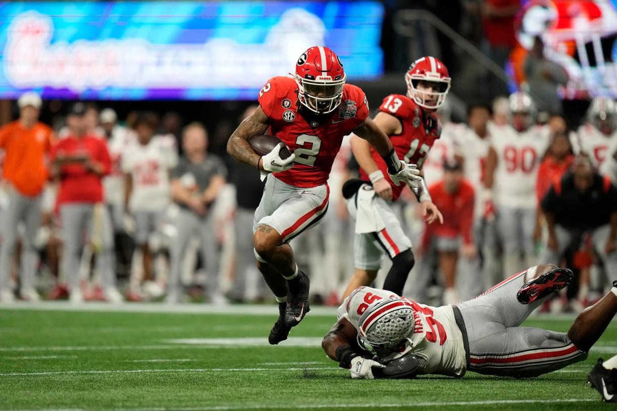 ATLANTA, GEORGIA - DECEMBER 31: Running back Kendall Milton (2) of the Georgia Bulldogs takes a handoff past defensive tackle Ty Hamilton (58) of the Ohio State Buckeyes during the first half of the 2022 College Football Playoff Semifinal at the Chick-fil-A Peach Bowl on December 31, 2022, in Atlanta, Georgia. (Photo by Paul Abell/Chick-fil-A Peach Bowl)