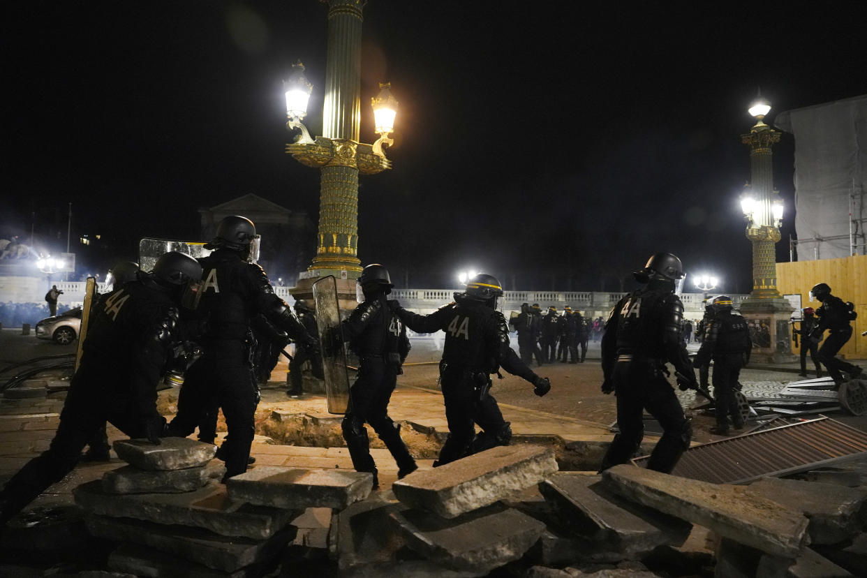 Police officers clear the Concorde square after a demonstration near the National Assembly in Paris, Thursday, March 16, 2023. French President Emmanuel Macron has shunned parliament and imposed a highly unpopular change to the nation's pension system, raising the retirement age from 62 to 64. (AP Photo/Lewis Joly)