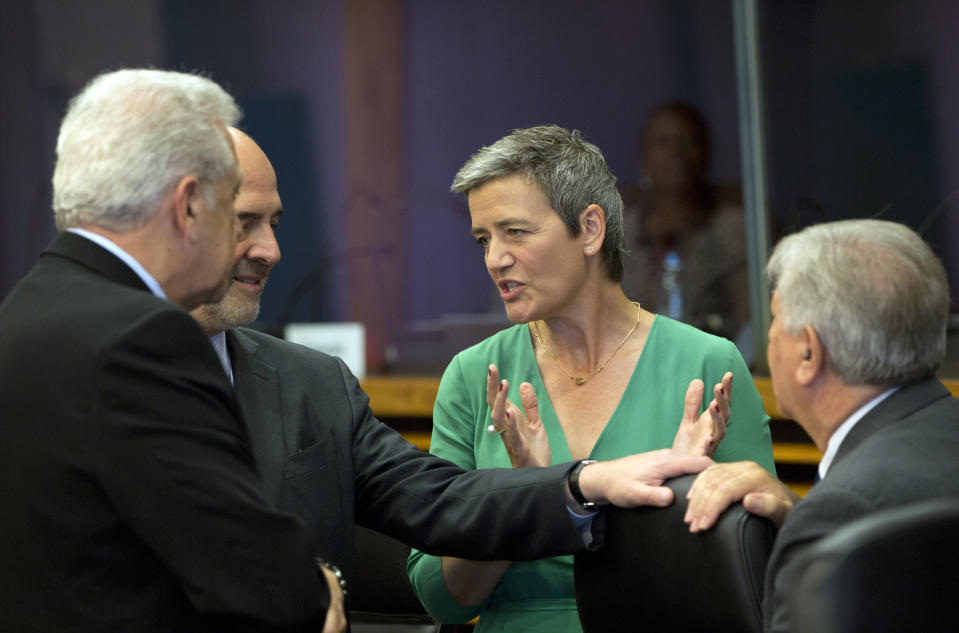 European Commissioner for Competition Margrethe Vestager, center, speaks with European Commissioner for Economic and Financial Affairs Pierre Moscovici, second left, and European Commissioner for Migration and Home Affairs Dimitris Avramopoulos, left, during the weekly college meeting at EU headquarters in Brussels, Wednesday, July 3, 2019. (AP Photo/Virginia Mayo)