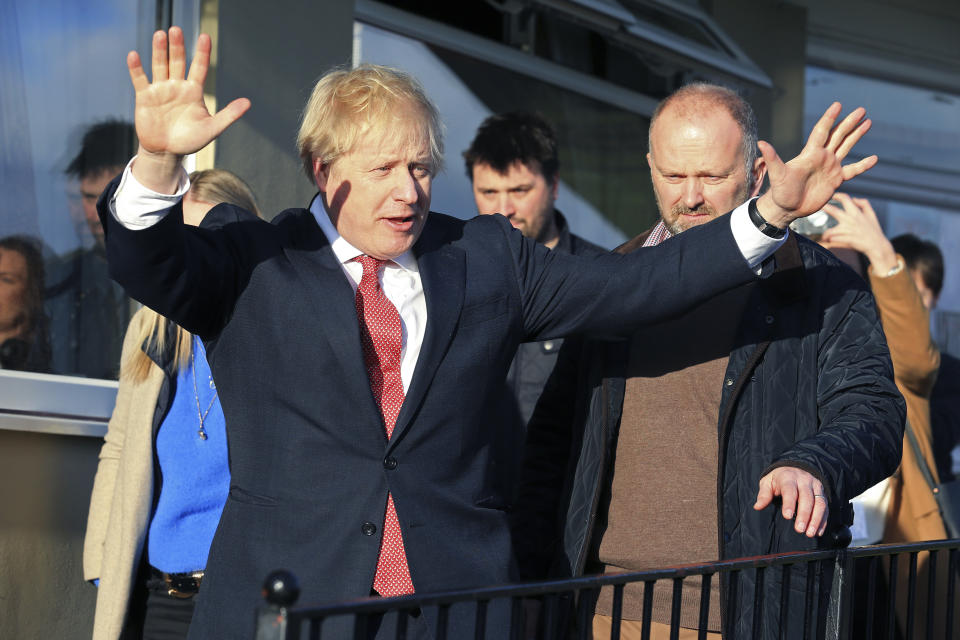 Britain's Prime Minister Boris Johnson gestures during a visit to newly elected Conservative party MP for Sedgefield, Paul Howell at  Sedgefield Cricket Club in County Durham, north east England, Saturday Dec. 14, 2019, following his Conservative party's general election victory.  Johnson called on Britons to put years of bitter divisions over the country's EU membership behind them as he vowed to use his resounding election victory to finally deliver Brexit. (Lindsey Parnaby/Pool via AP)