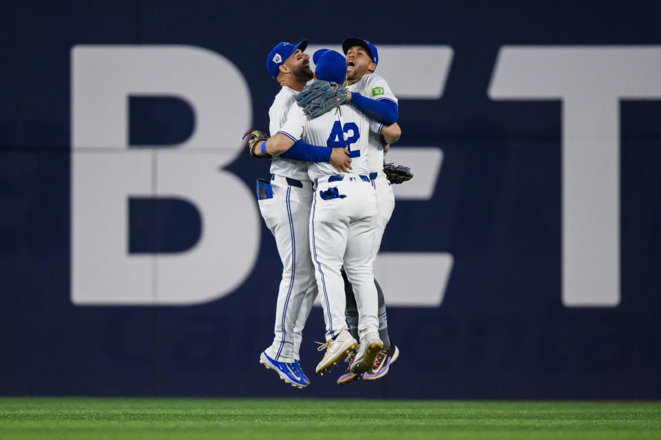 Toronto Blue Jays teammates Daulton Varsho, Kevin Kiermaier and George Springer celebrate after defeating the New York Yankees in a baseball game in Toronto on Monday, April 15, 2024. (Christopher Katsarov/The Canadian Press via AP)