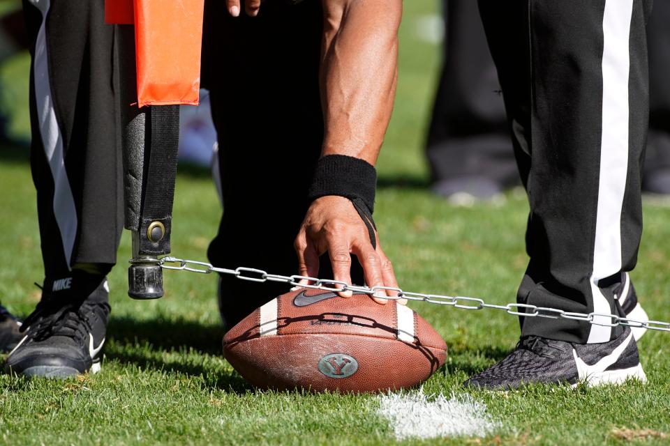 FILE - Officials measure for a first down during an NCAA college football game between USC and BYU, Saturday, Sept. 14, 2019, in Provo, Utah. For the first time since 1967, the game clock will continue to run when a team makes a first down rather than stopping until the chains are set and the referee gives the ready-for-play signal. The exception is during the last two minutes of the second and fourth quarters. (AP Photo/George Frey, File)