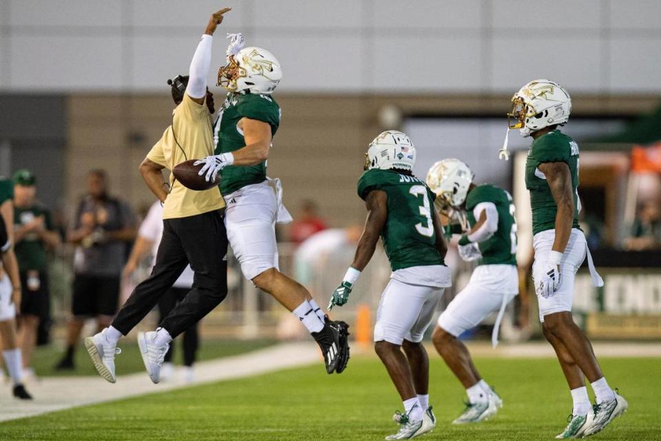 Sacramento State Hornets linebacker Brock Mather (10) celebrates with his position coach AJ Cooper after recovering a fumble during the first half of the NCAA football game at Hornet Stadium on Saturday.