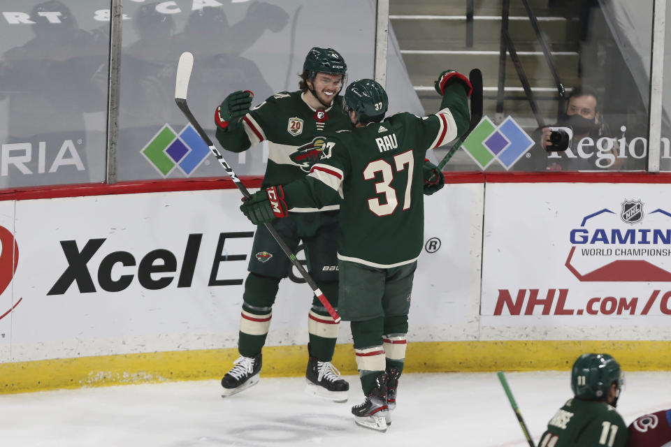 Minnesota Wild's Kyle Rau (37) celebrates with Luke Johnson (41) after Johnson scored a goal against the Colorado Avalanche during the first period of an NHL hockey game Wednesday, April 7, 2021, in St. Paul, Minn. (AP Photo/Stacy Bengs)