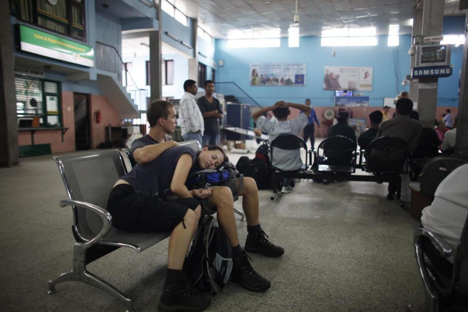 In this Wednesday, May 22, 2013 photo, passengers wait for a flight to Lukla which is delayed due to bad weather, at the airport in Katmandu, Nepal. Carved out of side of a mountain, the airport was built by Sir Edmund Hillary in 1965, and at an altitude of 2,843 meters (9,325 feet) the Lukla airport has earned the reputation of being one of the most extreme and dangerous airports in the world. (AP Photo/Niranjan Shrestha)