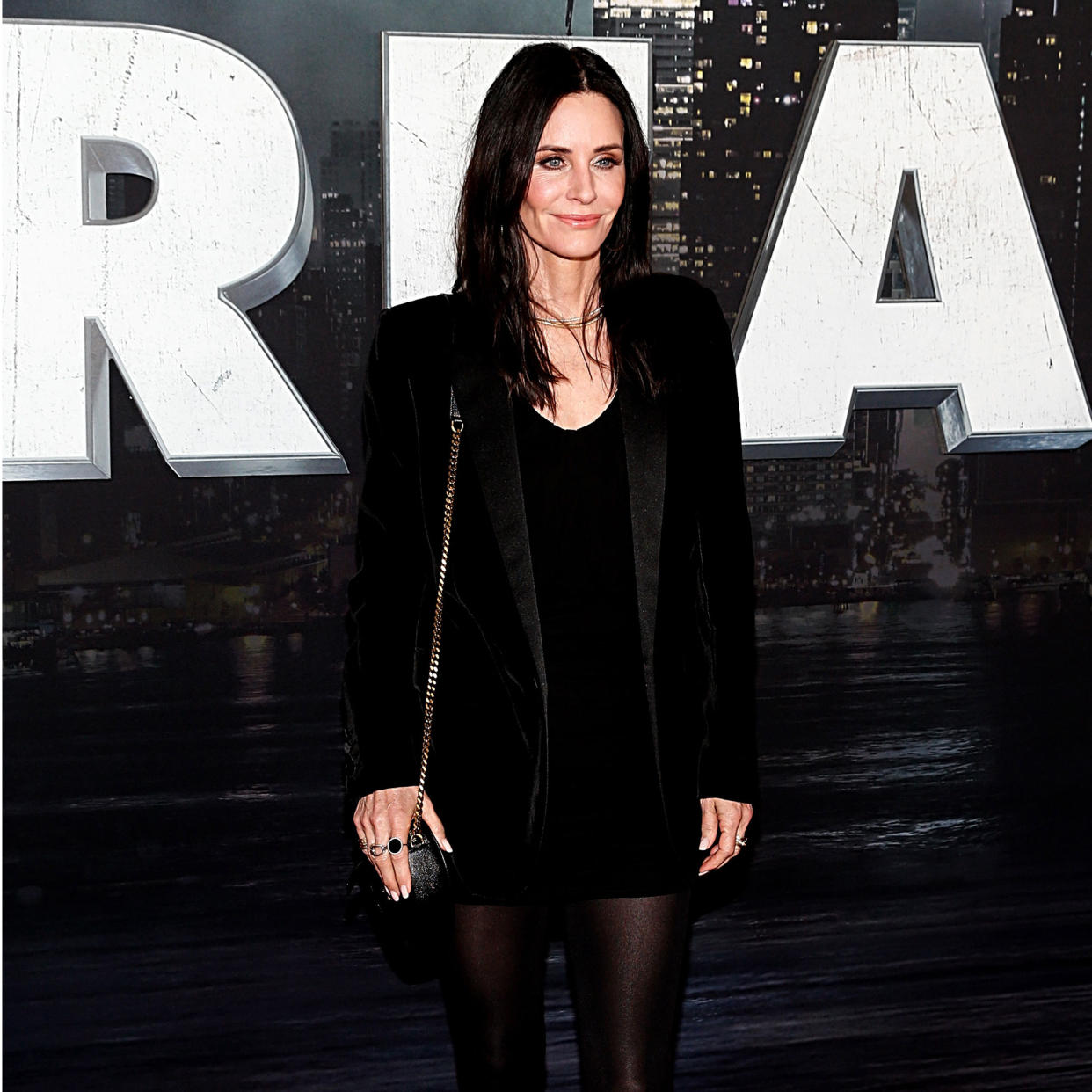  Courteney Cox on red carpet with scream poster in background. 