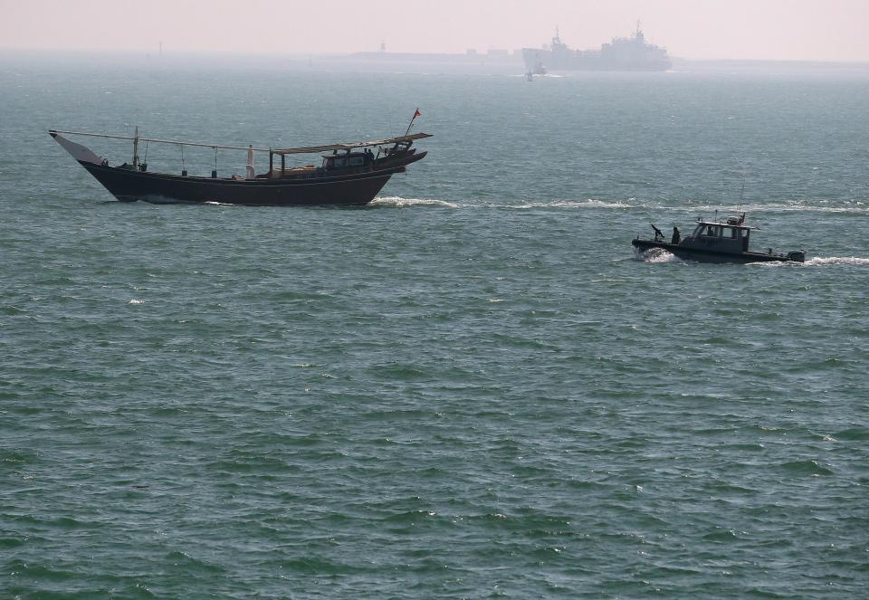 A U.S. Navy patrol boat follows a boat that passed near the USS Ponce where U.S. Secretary of Defense Chuck Hagel was taking a tour, in Manama